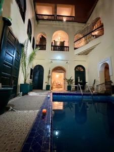 a swimming pool in a building with a house at Riad Sanwa in Marrakesh