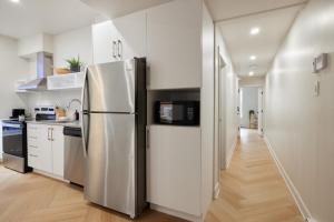 a kitchen with a stainless steel refrigerator with a microwave at Chic 2 Bedroom apartment in Le Plateau by Denstays in Montréal