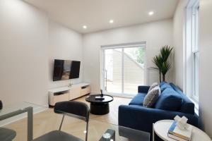 a living room with a blue couch and a tv at Chic 2 Bedroom apartment in Le Plateau by Denstays in Montréal