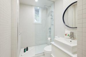Baño blanco con aseo y lavamanos en Chic 2 Bedroom apartment in Le Plateau by Denstays, en Montreal
