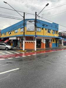 a blue and yellow building on the corner of a street at Hotel Pousada Liberdade in Pindamonhangaba