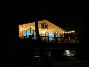 a house with christmas lights on the deck at night at Sacheon Songlim in Gangneung
