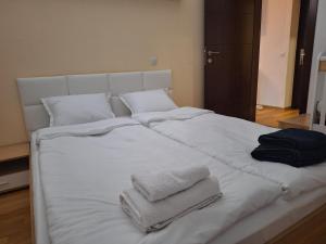 a bed with white sheets and towels on it at Danaya in Petrich