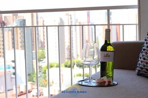 una botella de vino junto a una copa de vino en Manhattan View with pool, en Benidorm