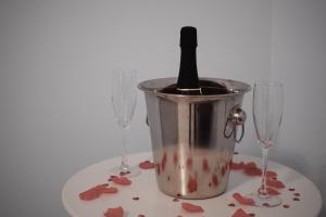 a bucket with a wine bottle in it next to two wine glasses at IN BLOOM ROOM b&b in Castel San Giorgio