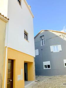 un edificio blanco y amarillo con una puerta al lado en Casa Angulosa, en Covilhã