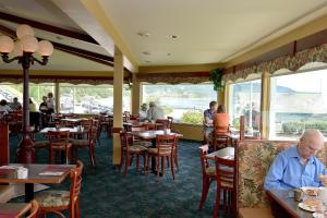 an older man sitting at a table in a restaurant at Auberge Sur Mer Charlevoix in Saint-Siméon