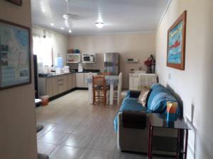 a living room with a couch and a kitchen at Casa privada - Balneário Gaivota-SC 150 metros do mar in Sombrio