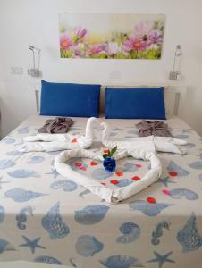 Corto Maltese Guest House في Cospicua: غرفة نوم عليها سرير وفوط