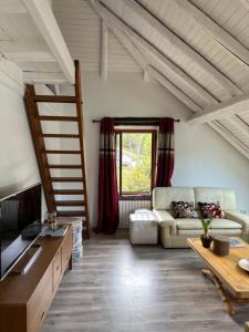 a living room with a couch and a loft at Gîtes Sous Les Loges in Lélex