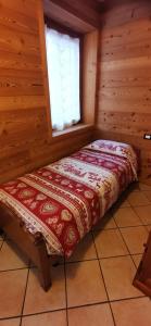 a bed in a room with a window at Trilocale BELVEDERE Alloggio ad uso turistico - VDA - LA THUILE - CIR 0068 in La Thuile