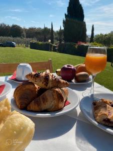 een tafel met borden en een glas sinaasappelsap bij Agriturismo La Luciana in Castiglione della Pescaia