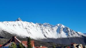 a snow covered mountain with a town in front at Peumayenlodge in Antuco