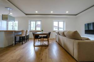 a living room and kitchen with a couch and a table at Apartamento T3 em Lisboa/ Queluz in Queluz