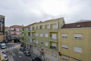 an apartment building with cars parked in a parking lot at Apartamento T3 em Lisboa/ Queluz in Queluz