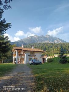 a house with a car parked in the driveway at Appartamento vacanze Riccardo ed Ester in Ronzo Chienis