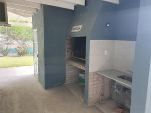 cocina con chimenea de ladrillo en una pared azul en Encanto Las Dunas, en Monte Hermoso