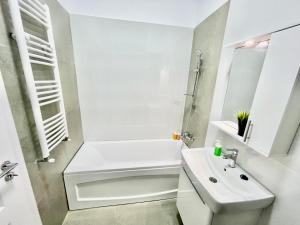 Un baño blanco con lavabo y ducha. en Central Adress AD8, en Bucarest 4 fotos más