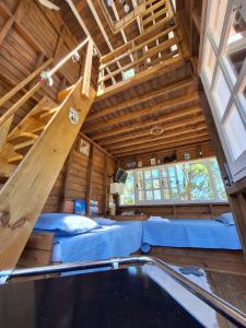 - une chambre avec un lit et une échelle dans l'établissement Casa na árvore perto da praia, à Imaruí