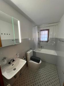 a bathroom with a sink and a toilet and a tub at Cosy studio for 4 near ski lift, CRETES B24 in Les Collons