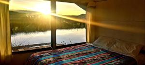 1 dormitorio con ventana y vistas al agua en Titicaca Vista amanecer, en Puno