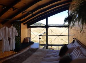 a bedroom with a bed and a large window at Cabana Cambará in Cambará