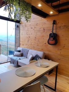 a living room with a couch and a guitar on the wall at Cabana Cambará in Cambará