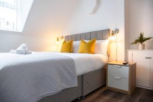 een slaapkamer met een groot bed met gele kussens bij Bootle, Liverpool Trendy 1Bed Ft in Liverpool