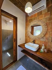 a bathroom with a sink and a mirror at Tawa Caraíva in Caraíva