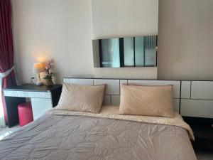 1 dormitorio con 1 cama con 2 almohadas y espejo en The Chezz by Apple & Frank en Pattaya centro