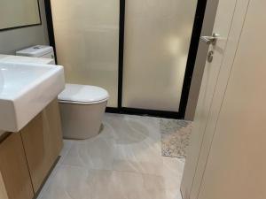a bathroom with a toilet and a sink and a shower at The Chezz by Apple & Frank in Pattaya Central
