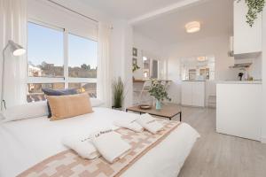 マラガにあるC79 - Fabulous Apartment Alcazaba Viewsの白いベッドルーム(大型ベッド1台付)、キッチンが備わります。