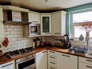 cocina con armarios blancos y fogones en Edge of Donard, Full house in Newcastle, en Newcastle