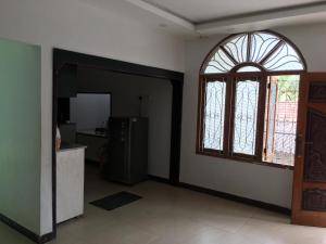 a living room with a window and a refrigerator at Sobia Villa in Jaffna
