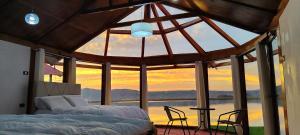- une chambre avec 2 lits et une grande fenêtre dans l'établissement Los Uros vista Ciudad Puno, à Puno