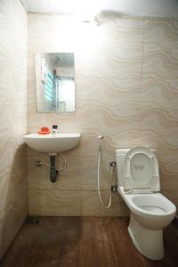 uma casa de banho com um lavatório, um WC e um espelho. em Sobia Villa em Jaffna