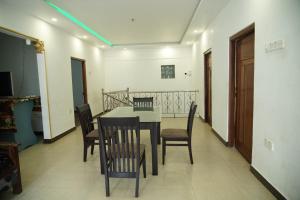 a dining room with a table and chairs at Sobia Villa in Jaffna +3 photos