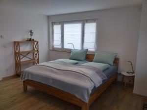 ein großes Bett in einem Zimmer mit Fenster in der Unterkunft Kleine Auszeit in Rust