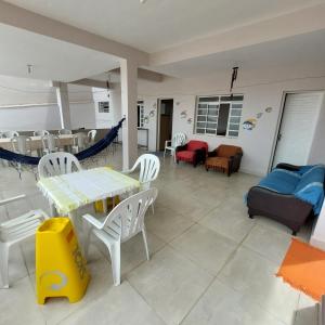 salon ze stołami, krzesłami i kanapą w obiekcie Hostel Muarama w mieście Passos