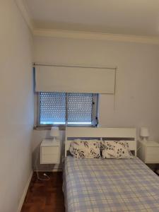 een slaapkamer met een bed en een raam bij K House in Odivelas