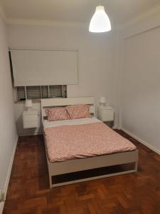 een slaapkamer met een bed en twee nachtkastjes bij K House in Odivelas