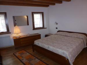 a bedroom with a bed and a dresser and a mirror at Casa Del Nonno in Tarzo