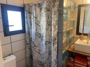 een badkamer met een douchegordijn en een wastafel bij Casa Las Cuevas in Málaga +36 foto's