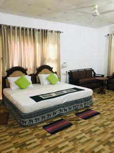 a bedroom with a large bed with green pillows at GreenSenz Resort & Hostel-Sigiriya in Sigiriya