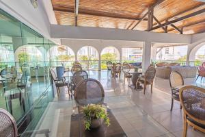 restauracja z krzesłami, stołami i oknami w obiekcie Hotel Village Premium Campina Grande w mieście Campina Grande
