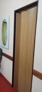 una puerta de madera en una habitación con espejo en Departamento a 200mts de la playa en Miramar