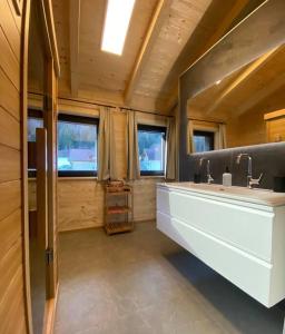 ein Badezimmer mit einem großen weißen Waschbecken und Fenstern in der Unterkunft Wohlfühlchalet Hermagor-Nassfeld-Weissensee in Hermagor