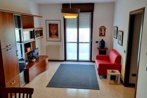 ein Wohnzimmer mit einem roten Sofa und einem roten Stuhl in der Unterkunft Appartamento Vista Panoramica in Agrate Brianza
