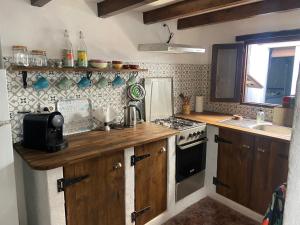 een keuken met houten kasten en een kookplaat met oven bij Casa Las Cuevas in Málaga