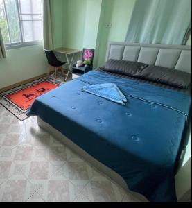 1 dormitorio con 1 cama azul grande en una habitación en JATUPORN A2 en Ban Talat Rangsit